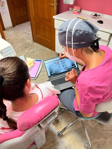 Explicamos tu diagnóstico con imágenes digitales Dentista muestra una radiografía panorámica en un portátil a una paciente en Presencia Dental